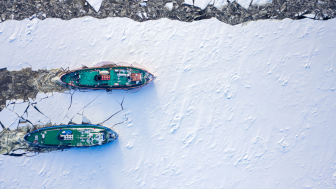 Ice breakers crush through the ice in an aerial shot